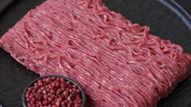 Raw ground beef or pork for burgers or meatballs with salt and spices. Raw ground beef as a food background for your design