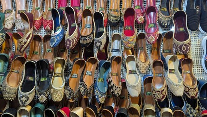 Row of colorful hand made traditional Rajasthan style shoes up for sale at street side in Area Hazro Attock. &lrm;November &lrm;28, &lrm;2025 