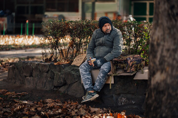 Homeless man needing food sitting in park