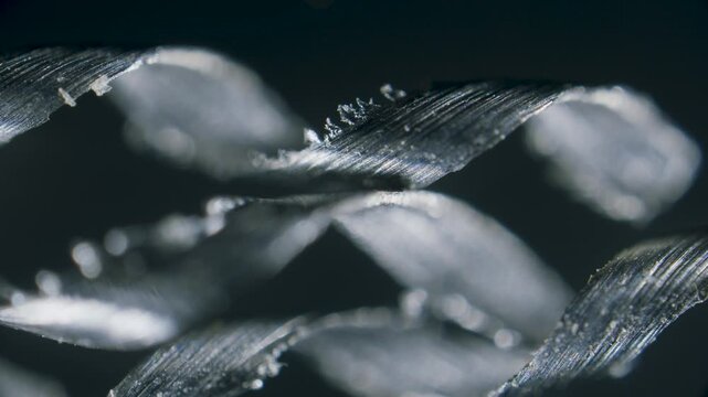 Titanium metal scrap shavings in spiral form under microscope on black background