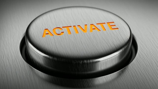 Close-up of a metallic button with the word activate in orange text on the surface of the button