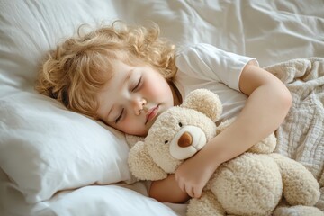 Young child with curly blonde hair sleeps peacefully with soft stuffed bear. Toddler rests on white pillow, blanket, embraced by soft light. Adorable scene captures childhood innocence, bedtime