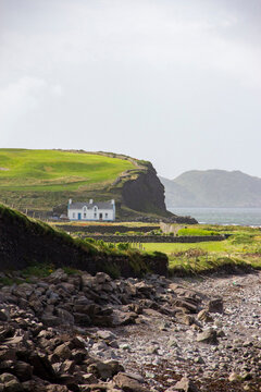 White Cottage on Green Clifftop Overlooking the Irish Coast