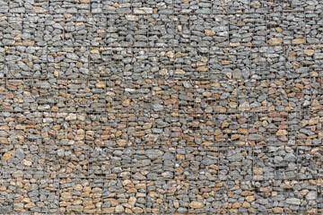 Tekstura kamiennego muru z drobnych otoczaków – szare tło z kamieni, naturalny wzór i chropowata powierzchnia. © Henryk Guziak