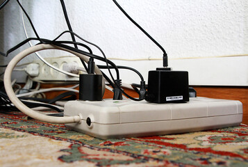 Cables el&eacute;ctricos enchufados a corriente y ladr&oacute;n con regleta y conexi&oacute;n de cableado en suelo