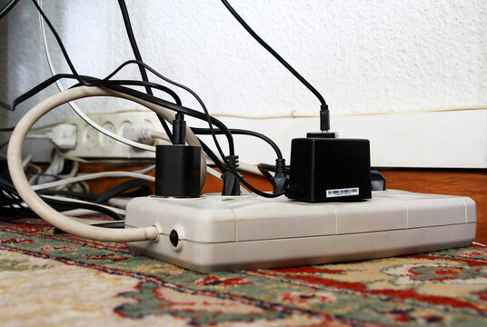 Cables el&eacute;ctricos enchufados a corriente y ladr&oacute;n con regleta y conexi&oacute;n de cableado en suelo