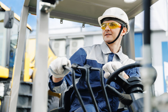 Young Caucasian male worker operating machinery in logistics warehouse