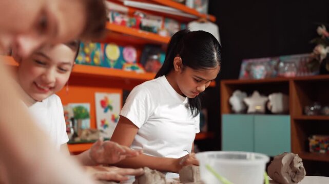 Skilled multicultural children sculpting clay at pottery workshop. Smart diverse high school working at clay by using craving equipment at art lesson. Creative activity concept. Education. Edification
