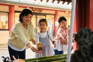 Japanese mother and daughters performing temple purification ritual