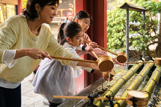 Japanese family performing purification ritual at temple