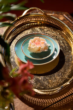 Rose dessert on a decorative tray in a warm room