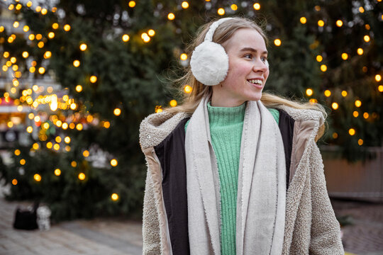 Young woman wearing earmuffs at Christmas market in Helsinki, Finland