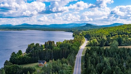 Obraz premium Aerial View of Scotch Cap, Quebec, Canada, and a Winding Road Through Forested Landscape Near a Lake
