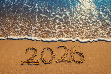 Happy New Year 2026 number lettering on the beach sand and sea wave