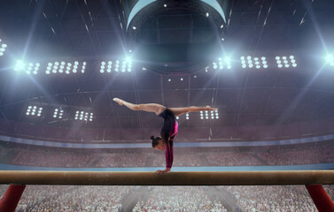 A gymnast performs a difficult trick on a balance beam.