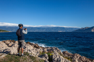 Fototapeta premium Radfahrer fotografiert Adria von felsiger Küste