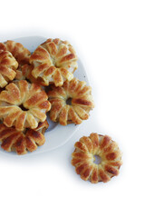 Homemade puff pastry apple rings with cinnamon and cane sugar on white ceramic plate on white background 