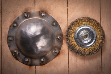 Fototapeta premium Shield boss manufacturing and polishing with angle grinder on wooden background.