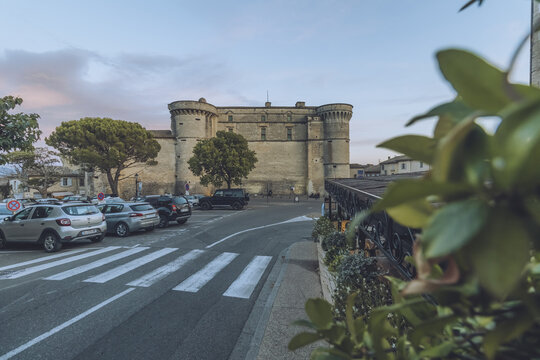 View of the imposing Chateau de Gordes, a medieval fortress in the evening light, casting a long shadow over the roads and flora, Gordes, Provence-Alpes-C&ocirc;te d'Azur, France.