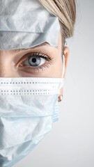 Close-up portrait of a person wearing protective face masks, highlighting the eye and forehead protection.