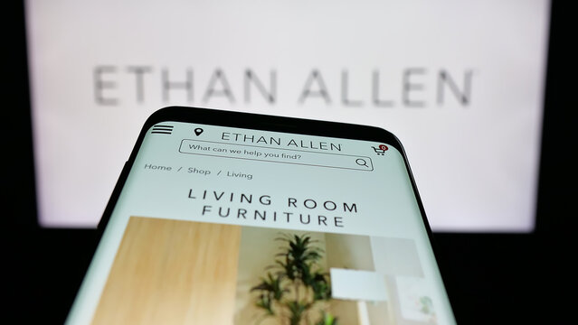 Stuttgart, Germany - 12-10-2025: Mobile phone with website of furnishing company Ethan Allen Interiors Inc. on screen in front of logo. Focus on top-left of phone display.