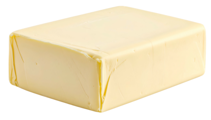 A close-up shot of a rectangular block of butter, wrapped in paper, with a creamy yellow color. The light and shadows give depth