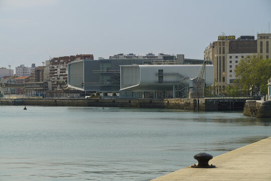 View of the Centro Bot&iacute;n art museum's modern lines contrast with the calm bay waters under a bright sky, Santander, Cantabria, Spain.