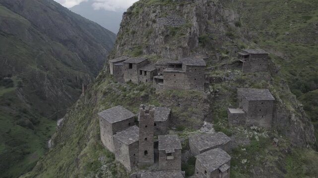 Stunning scenery of the ancient stone mountain village of Mutso in the Khevsureti region of Georgia, featuring dramatic architecture set within a rugged alpine landscape