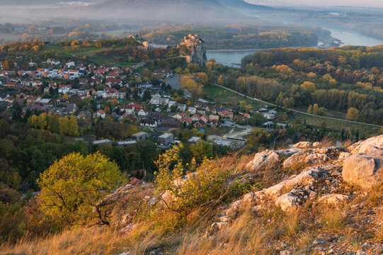 View of autumn hues paint the landscape, framing the ancient Devin Castle perched above a village nestled by the Danube's shimmering waters, Devinska Nov&aacute; Ves, Bratislava Region, Slovakia.
