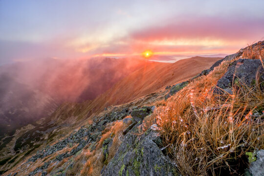 View of a dramatic sunrise paints the rugged mountain peaks in fiery hues, casting a warm glow over the misty valleys, Skalka, Banska Bystrica Region, Slovakia. - Powered by Adobe