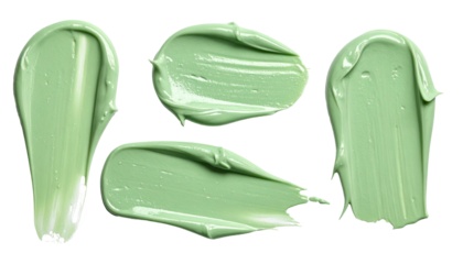 Close-up of four green cosmetic cream samples against black