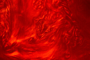 Shimmering red abstract background. Liquid glitter paint texture waves and swirls. Beautiful shiny...