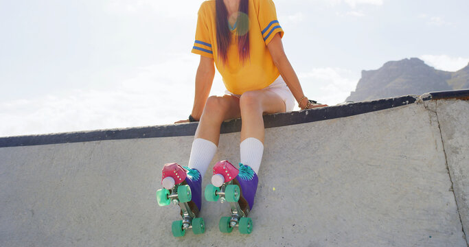 Woman, legs or urban park with roller skates for fitness, aerobic exercise or outdoor hobby. Female person, hipster or balance with wheels or rollerskating for parkour sport on concrete legde in city