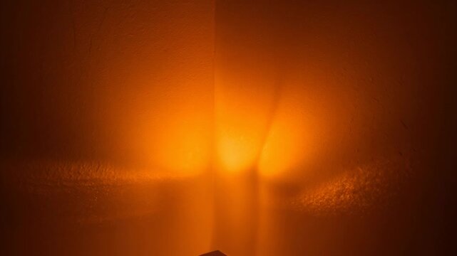 Flickering warm light core shifting via frosted panel in closeup seam forming bands and triangle