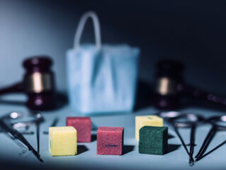 Medical cubes on sterile table with surgical tools and gavel suggesting legal medical dispute and tense atmosphere