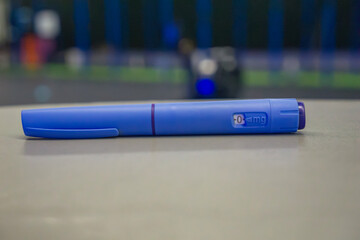 Ozempic injection pen diabetes medication neutral surface indoor gym background with copy space for...