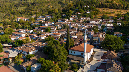 Obraz premium Aerial view of Sirince village in Turkey with traditional houses and mosque surrounded by green hills. Historic rural settlement, cultural heritage and popular travel destination.