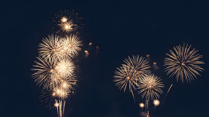 Colorful pyrotechnics display of exploding fireworks in the bright night sky over the river during a New Year holiday festival celebration.