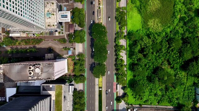 Aerial top view footage of traffic activity along Jenderal Sudirman Street in Jakarta, Indonesia.
