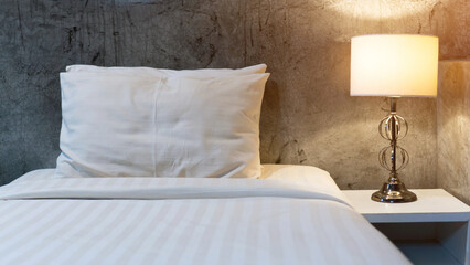 White bed, pillow, and lamp in the bedroom.