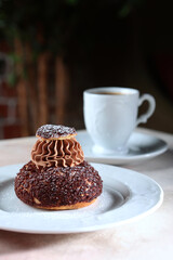 French biscuits with peach jam. A custard cake. A white cup with coffee. A confection. A sweet feast.