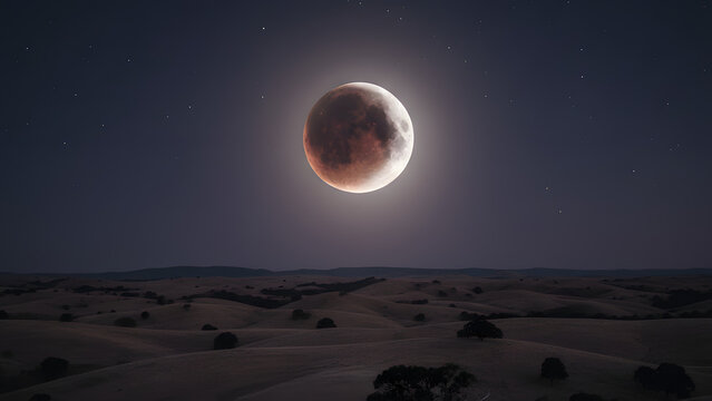 Dramatic Lunar Eclipse Over Desert Landscape Under Night Sky