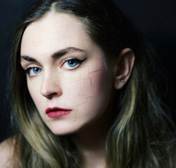 Woman with cracked on face as cosmetic and dehydration effect concept.