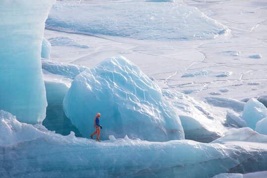 Climbers on a glacier in Iceland. A beautiful sunny winter day. A man climbing on a glacier in Iceland. They have a rope, ice axes, and crampons. Sunny day.