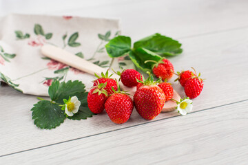 Ripe red strawberries on a light wooden table