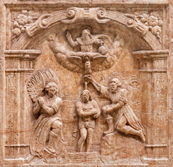 SALZBURG, AUSTIRA - SEPTEMBER 8 2025: The stone relief of Baptism of Christ on exterior wall of the chapel Margarethenkapelle in the St. Peter Abtei cemetery by unknown artist.