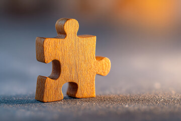 Single wooden puzzle piece standing upright on textured surface with warm light creating soft shadows and blurred background for concept focus