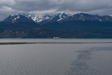 Aerial view of a ship sailing across the tranquil waters against the backdrop of snow-capped mountains, Puerto Williams, Chile.