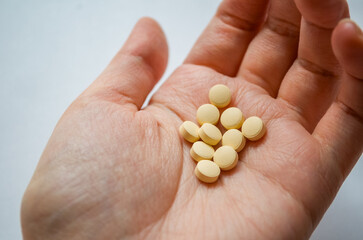 Human hand holding multiple yellow tablets