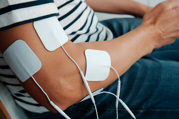man sitting with electrode pads on his arm